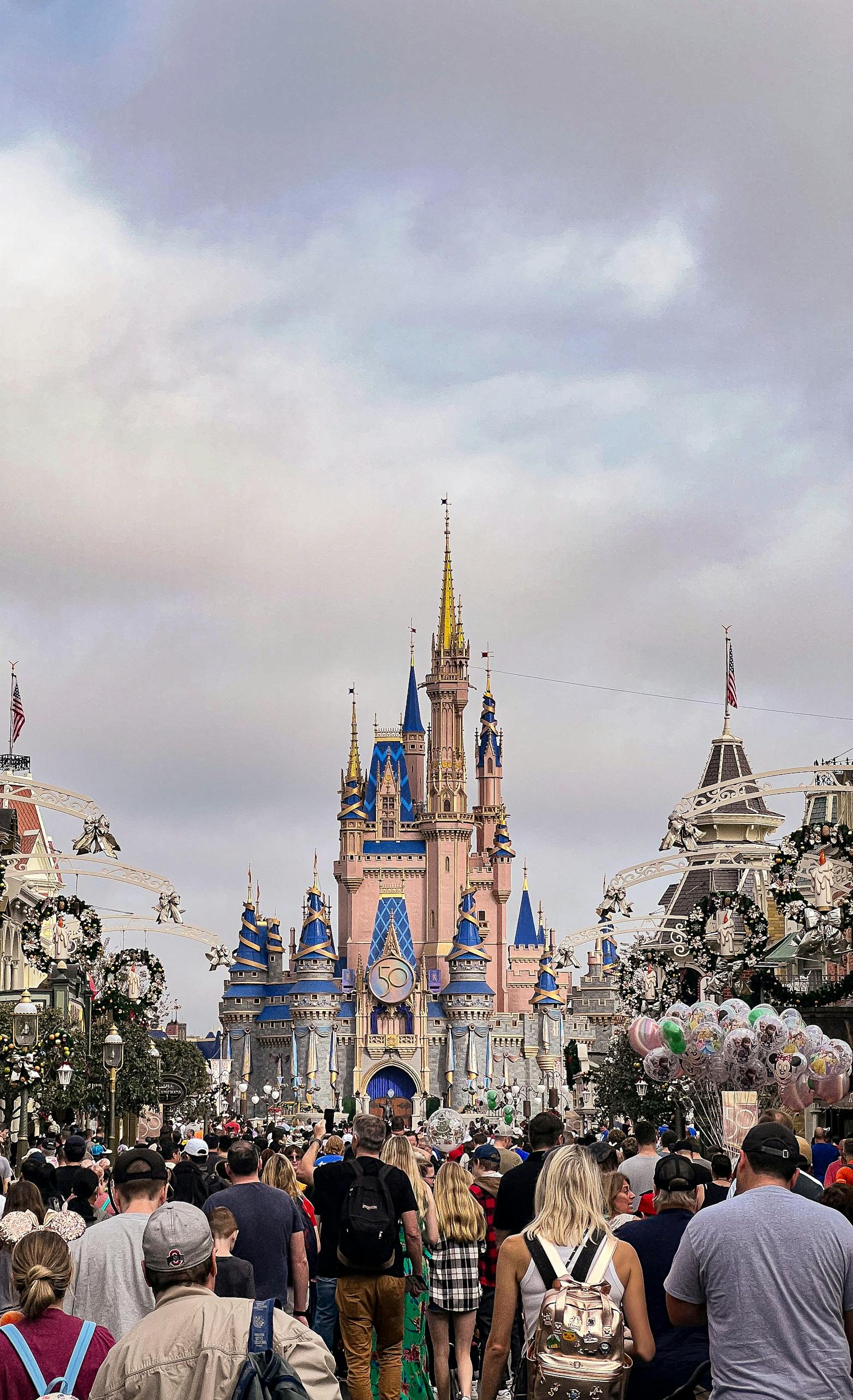 A bustling crowd approaches the iconic Cinderella Castle in Magic Kingdom, Florida.