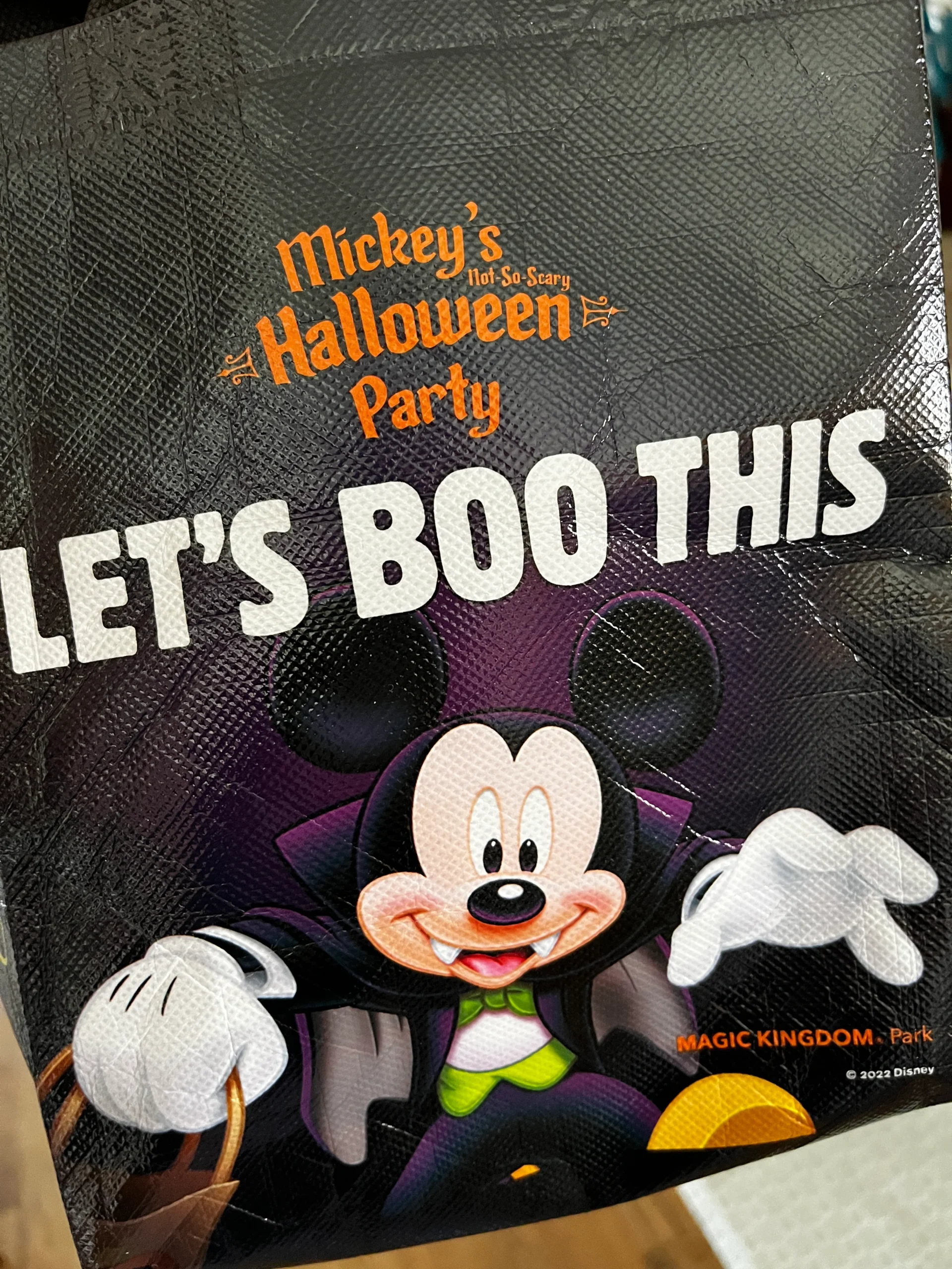 Mickey Mouse dressed as Count Dracula decorates a small candy bag for the 2022 Mickey's Not So Scary Halloween Party.