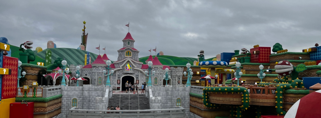 Peach's grey castle and pink roof is centered in the landscape.