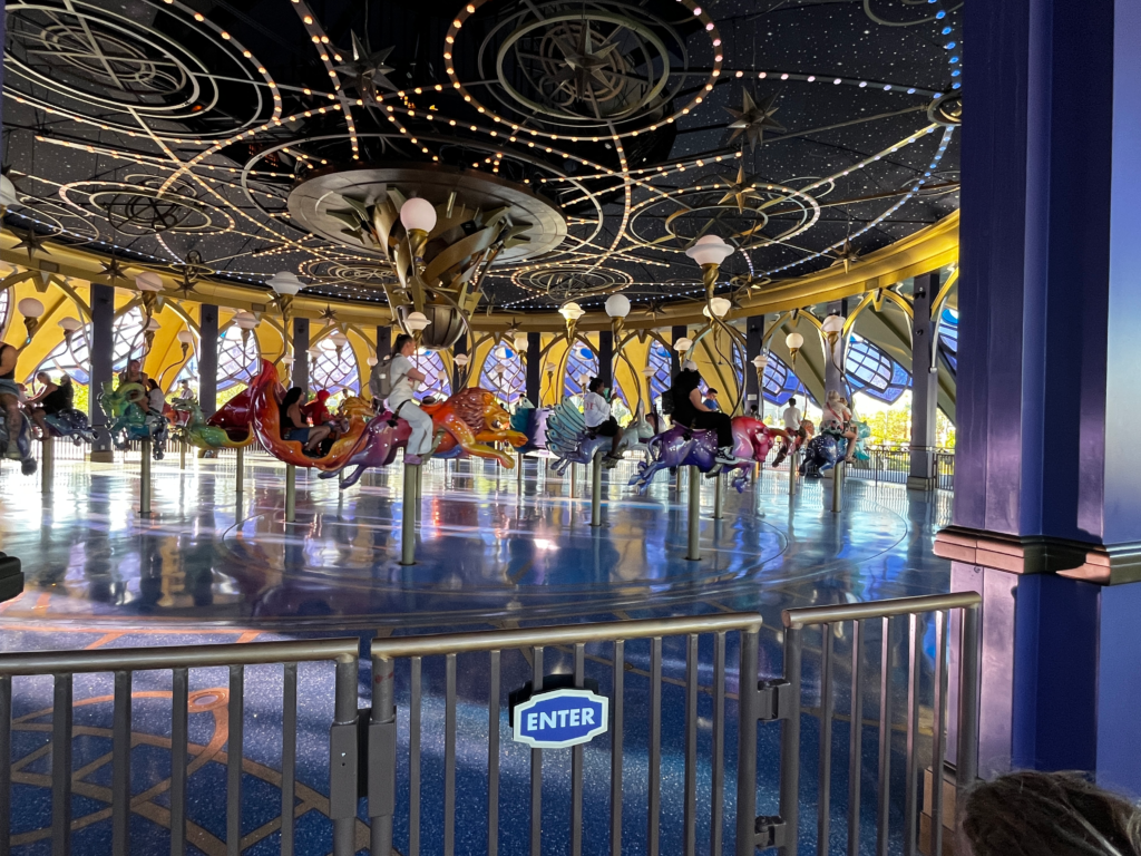 Riders on a carousel sit on animals representing the constellations.