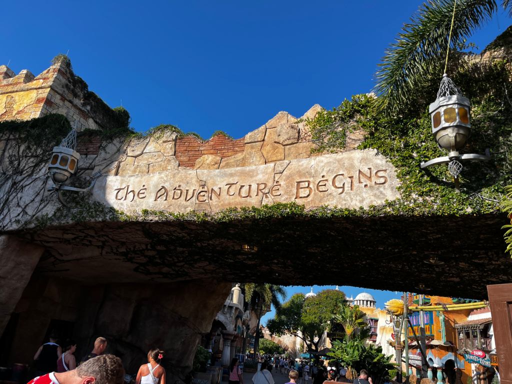 A stone archway hangs over visitors at Islands of Adventure. 