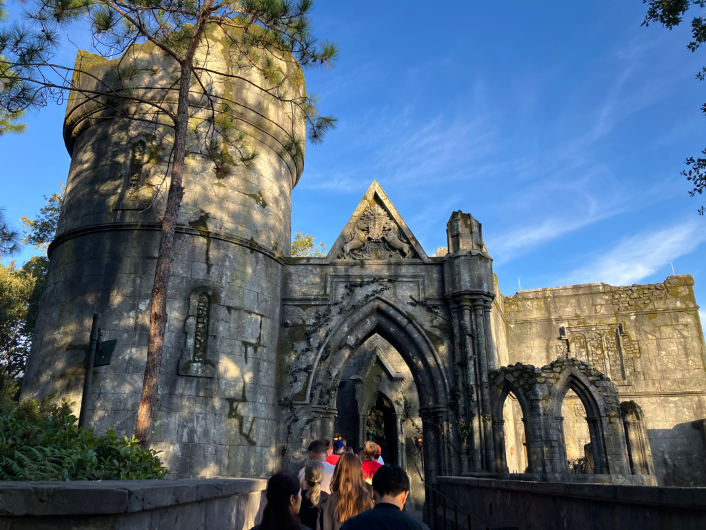 A medievil style building with turret welcomes visitors through an arch with unicorns carved in the peak.